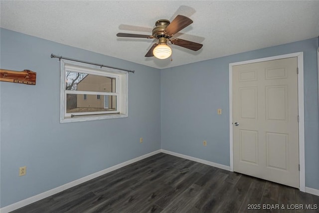 spare room featuring ceiling fan, dark hardwood / wood-style flooring, and a textured ceiling