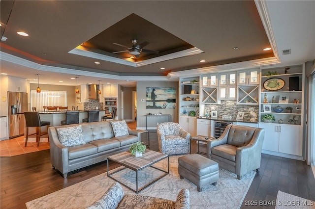 interior space featuring a raised ceiling, ceiling fan, crown molding, and beverage cooler