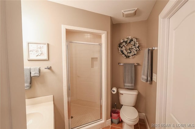 bathroom with tile patterned floors, toilet, and a shower with door