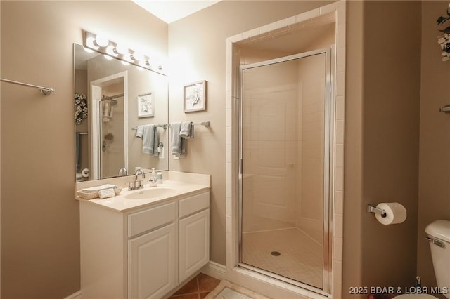 bathroom with tile patterned flooring, vanity, toilet, and walk in shower