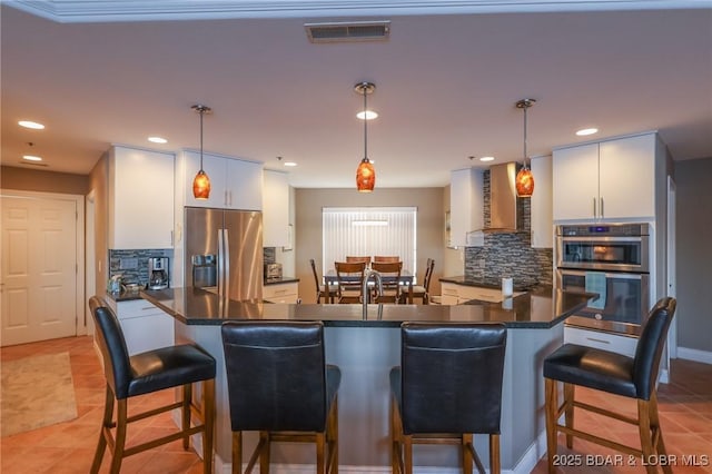 kitchen with a kitchen bar, kitchen peninsula, pendant lighting, and appliances with stainless steel finishes