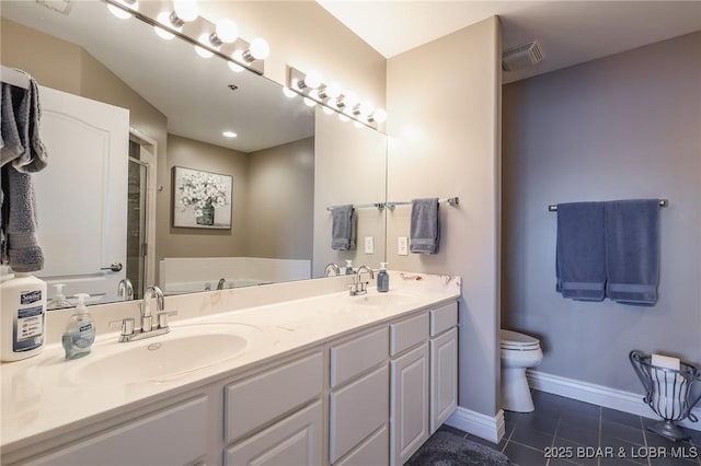 bathroom featuring tile patterned flooring, vanity, toilet, and a washtub