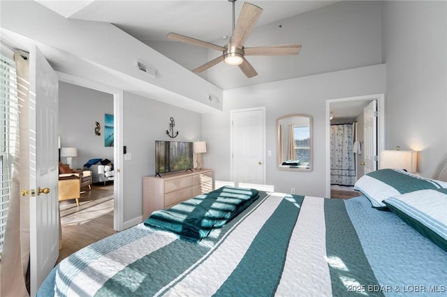 bedroom with lofted ceiling, ensuite bathroom, wood finished floors, visible vents, and a ceiling fan