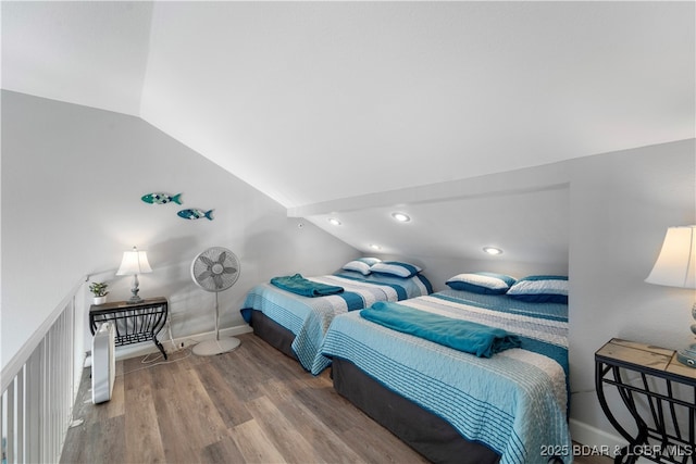 bedroom with baseboards, vaulted ceiling, and wood finished floors