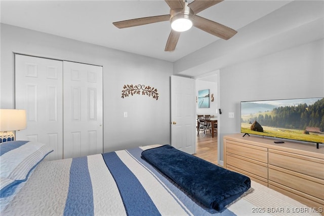 bedroom featuring ceiling fan, a closet, and light wood-type flooring