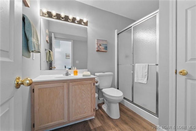 full bathroom with toilet, a stall shower, wood finished floors, and vanity