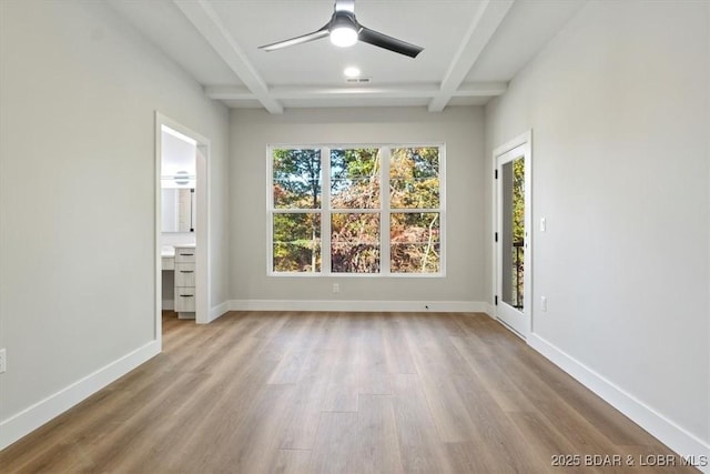 empty room with coffered ceiling, ceiling fan, light hardwood / wood-style flooring, and beamed ceiling