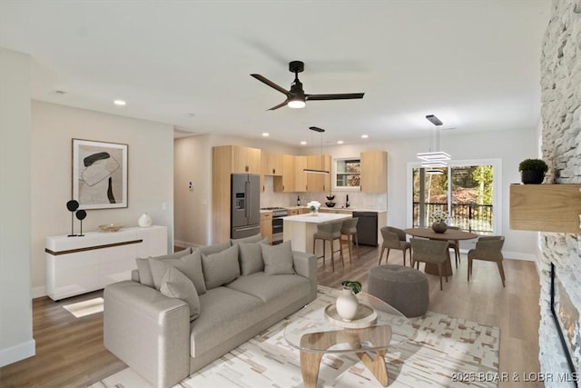 living room featuring ceiling fan and light wood-type flooring