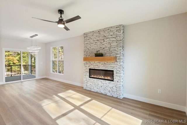 unfurnished living room featuring wood-type flooring, ceiling fan, and a fireplace