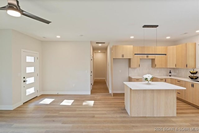 kitchen with decorative backsplash, light brown cabinets, and light hardwood / wood-style flooring