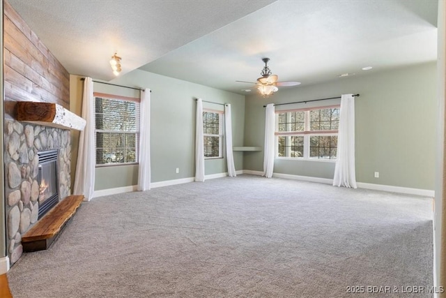 unfurnished living room with a fireplace, a textured ceiling, carpet floors, and ceiling fan