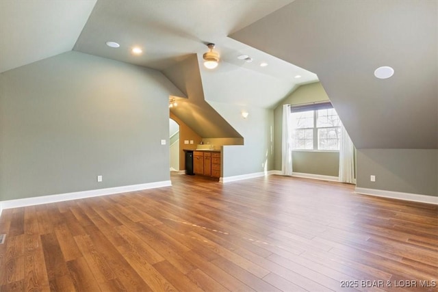 additional living space with hardwood / wood-style flooring, ceiling fan, and lofted ceiling