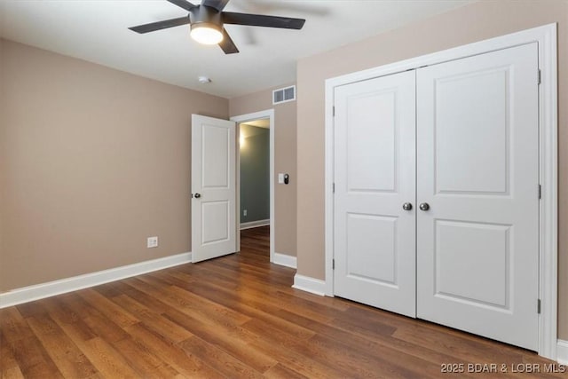 unfurnished bedroom featuring ceiling fan, a closet, and hardwood / wood-style floors