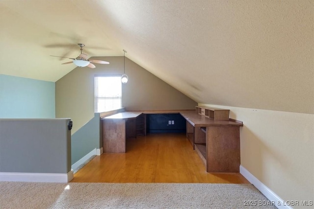 additional living space with ceiling fan, light hardwood / wood-style floors, and vaulted ceiling