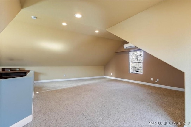 additional living space featuring lofted ceiling, light colored carpet, and a wall mounted air conditioner