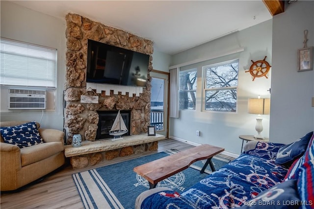 living room featuring cooling unit, wood-type flooring, and a fireplace