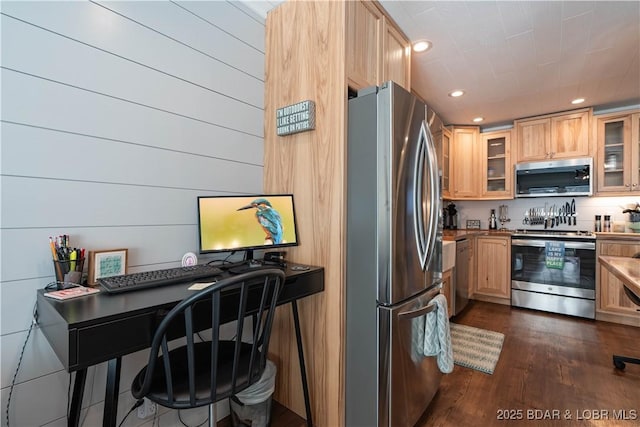 kitchen featuring light brown cabinets, wooden walls, stainless steel appliances, and dark wood-type flooring