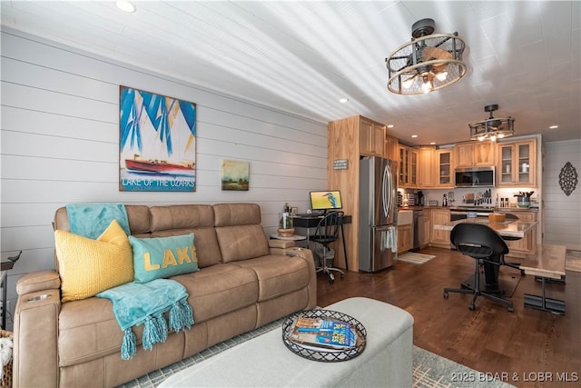 living room featuring dark hardwood / wood-style flooring and wooden walls