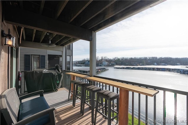 deck with ceiling fan and a water view