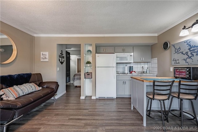 kitchen featuring white appliances, gray cabinets, a textured ceiling, tasteful backsplash, and dark hardwood / wood-style flooring