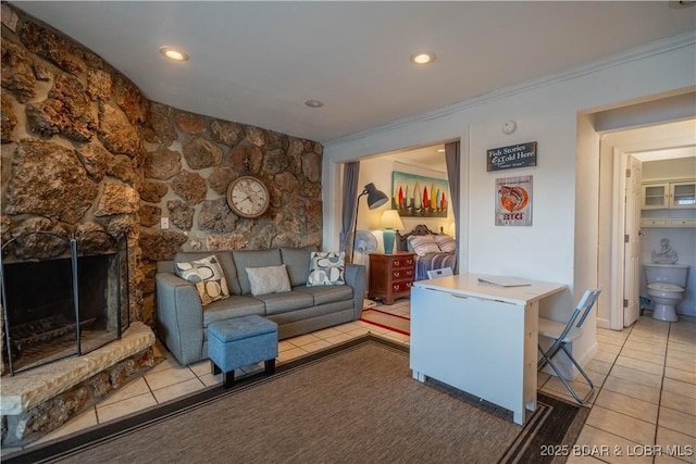 living room with a fireplace, light tile patterned floors, and ornamental molding