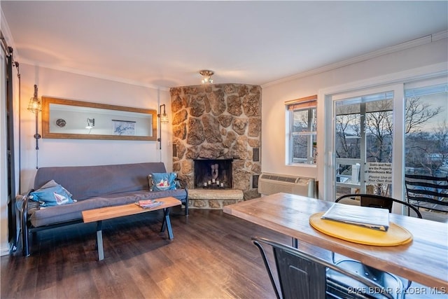 living room featuring a fireplace, hardwood / wood-style floors, a wall mounted air conditioner, and ornamental molding