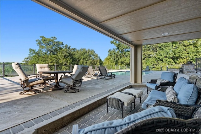 view of patio with an outdoor living space with a fireplace and a fenced in pool