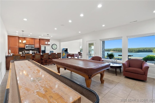 playroom with light tile patterned floors, a water view, and pool table