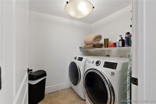 laundry room with washer and dryer and light tile patterned flooring