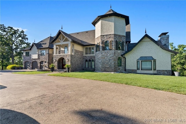 french country inspired facade featuring a garage and a front lawn