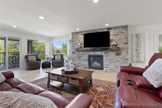 living room with a fireplace, light tile patterned floors, and a healthy amount of sunlight