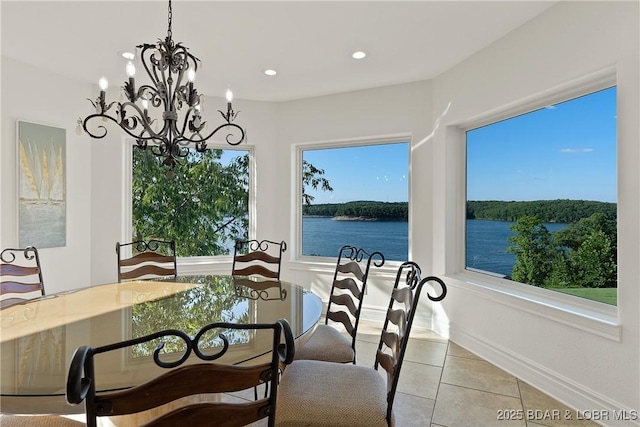 tiled dining space featuring a water view and a chandelier