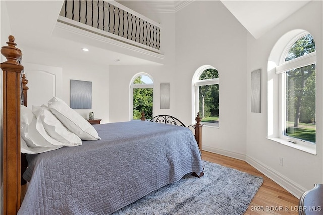 bedroom with hardwood / wood-style flooring and multiple windows