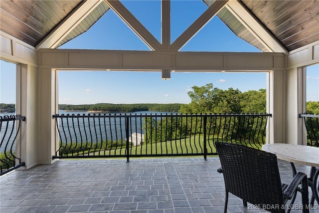 sunroom / solarium with a water view and vaulted ceiling