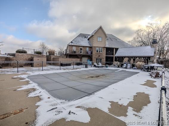 snow covered pool featuring a patio