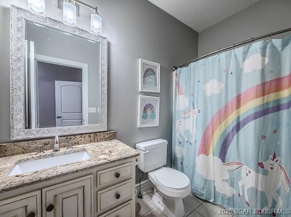 bathroom featuring a shower with curtain, tile patterned floors, a textured ceiling, toilet, and vanity