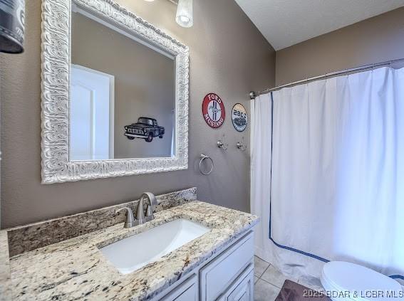 bathroom featuring tile patterned floors, vanity, toilet, and walk in shower