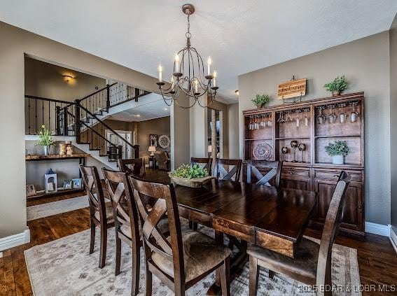 dining space featuring dark hardwood / wood-style flooring and a chandelier