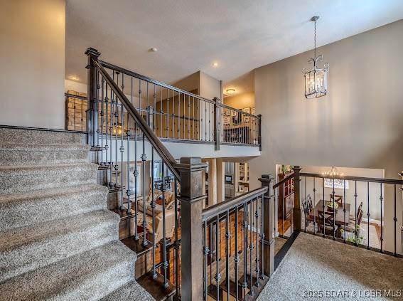 stairway with a high ceiling and an inviting chandelier