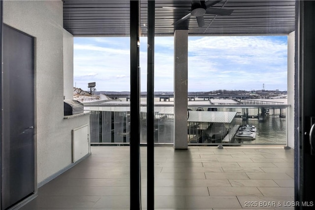 balcony featuring a water view and ceiling fan