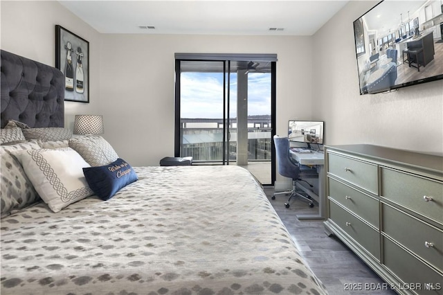 bedroom featuring access to exterior and dark hardwood / wood-style flooring