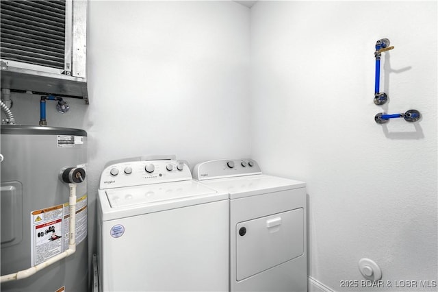 clothes washing area featuring electric water heater and separate washer and dryer