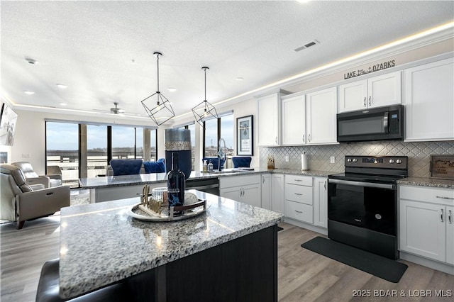 kitchen featuring electric range, sink, white cabinets, and ceiling fan