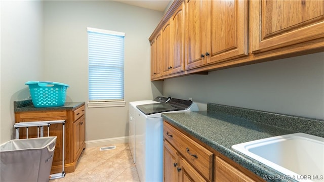 washroom featuring cabinets, light tile patterned flooring, washer and clothes dryer, and sink