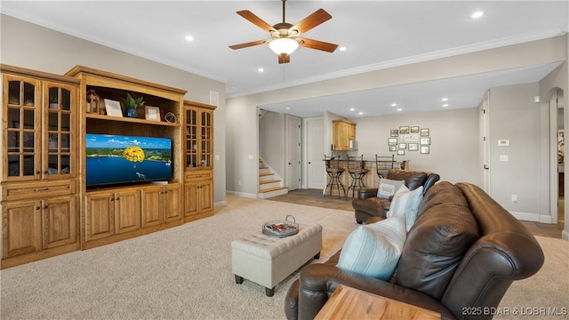 living room featuring light carpet, ceiling fan, and ornamental molding