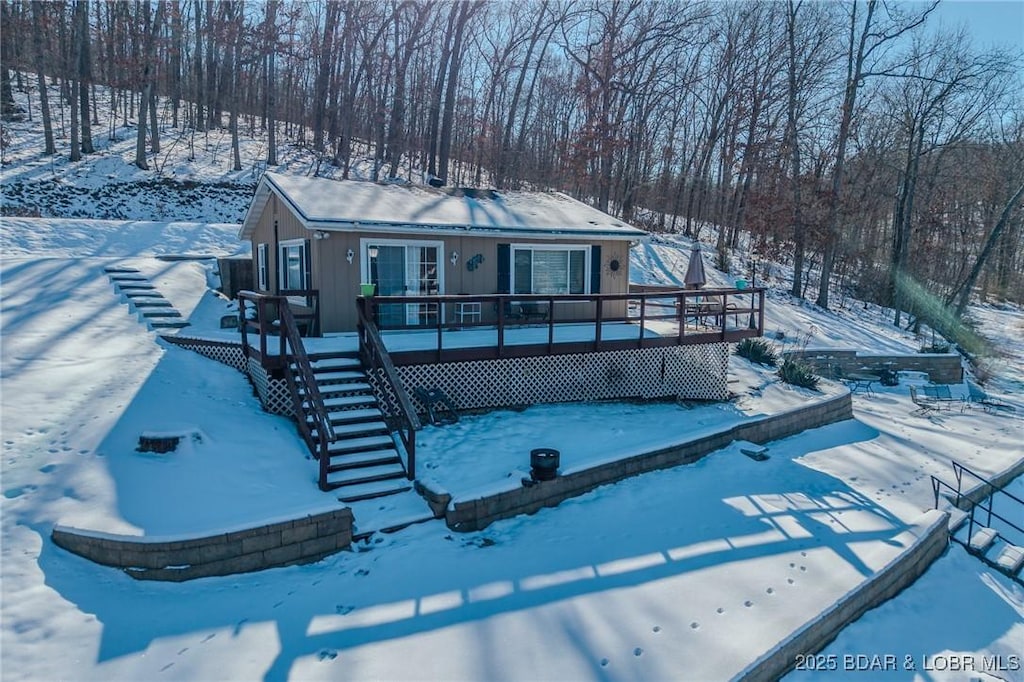 snow covered house with a deck