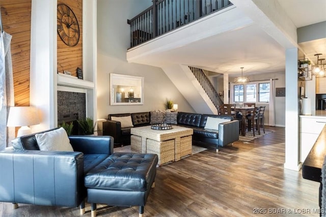 living room featuring dark wood-type flooring, a fireplace, and a notable chandelier