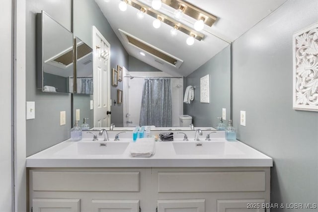 bathroom featuring vanity, lofted ceiling, walk in shower, and toilet