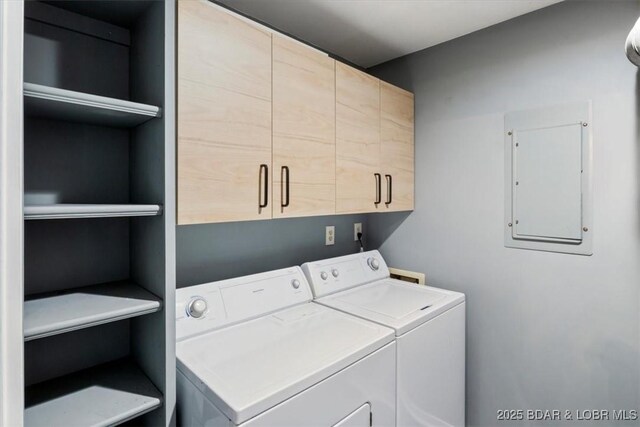 washroom with cabinets, electric panel, and washing machine and clothes dryer