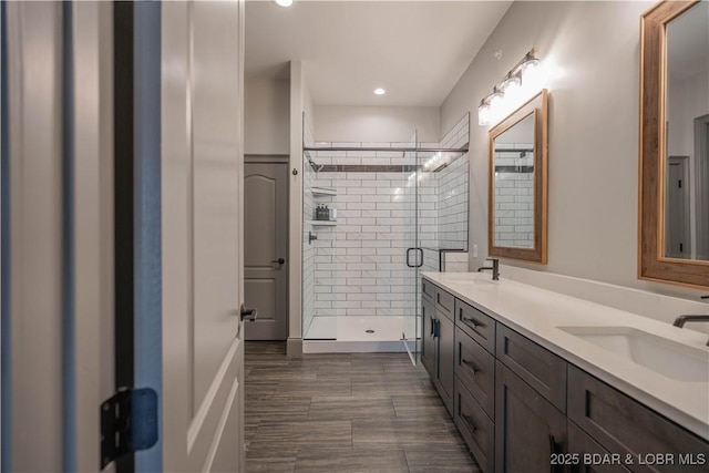 bathroom with vanity and a shower with door